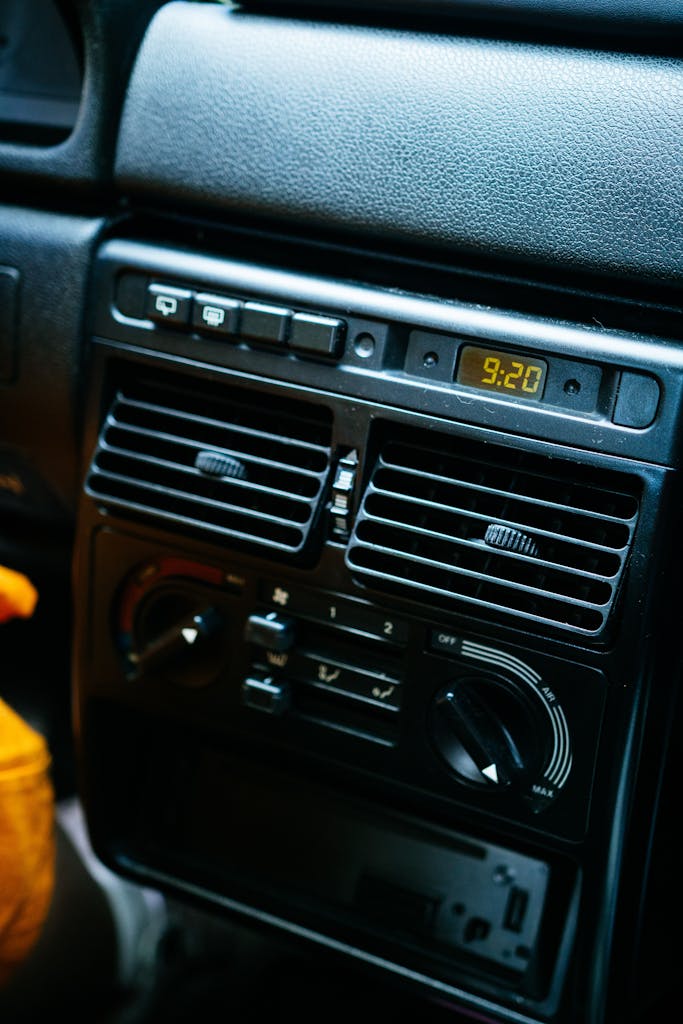 Detailed view of a car dashboard with electronic controls and digital clock.